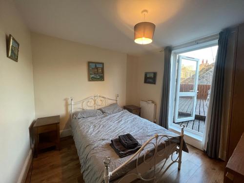 a bedroom with a bed and a large window at Lovely 2 Bedroom Apartment with Balcony - Euston in London