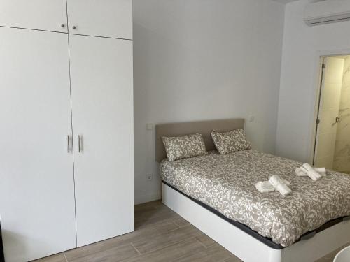 een slaapkamer met een bed en een witte kast bij San Sebastián Apartments in San Sebastián de los Reyes