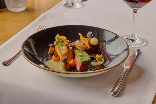 a bowl of food on a table with a fork and knife at Wellness Hotel Stoos in Stoos