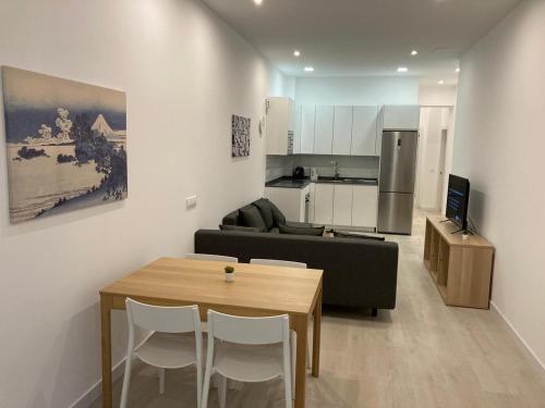 a kitchen and a living room with a table and a couch at Matadero Apartments 3 in Madrid