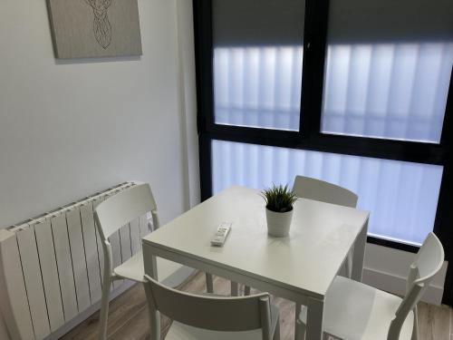 a white table and chairs in a room with a window at Plaza Castilla Apartments in Madrid