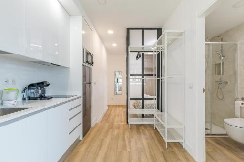 eine Küche mit weißen Schränken, einem Waschbecken und einem WC in der Unterkunft Arturo Soria Apartments2 in Madrid