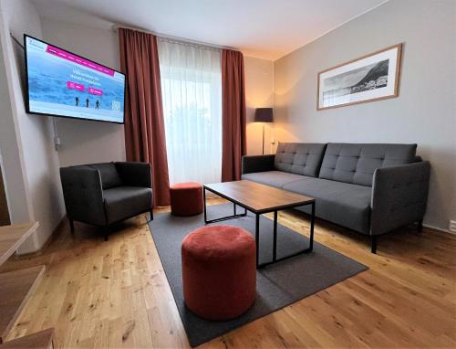 a living room with a couch and a table and a tv at Hotell Funäsdalen in Funäsdalen