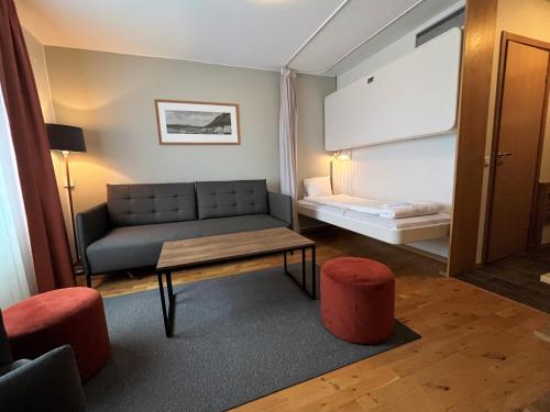 a living room with a couch and a table at Hotell Funäsdalen in Funäsdalen