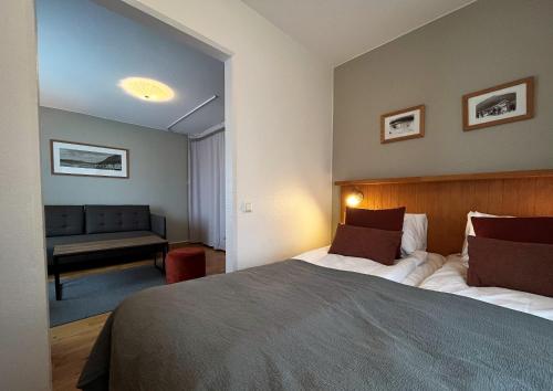 a bedroom with a large bed and a couch at Hotell Funäsdalen in Funäsdalen