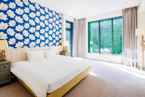 a bedroom with a large bed with a blue and white wallpaper at AMO 54 by Hakuba Hotel Group in Hakuba