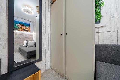 a room with a mirror and a bed in it at Hauzify I Apartament Turismar in Platja  d'Aro
