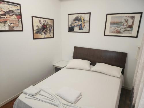 um quarto com uma cama com quatro fotografias na parede em V-Appartment em Tirana