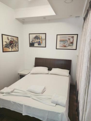 um quarto com uma cama grande e lençóis brancos em V-Appartment em Tirana