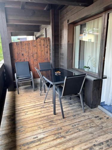 a black table and chairs on a wooden deck at Weidach Zentrum 1 in Leutasch