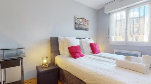 een slaapkamer met een groot bed met rode en witte kussens bij Petite France with 1 free parking in Straatsburg