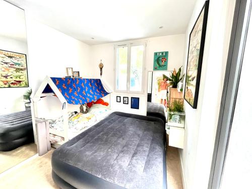 - une chambre avec un lit au milieu d'une pièce dans l'établissement PARIS Maison Exception Terrasse Jacuzzi Parking gratuit, à Saint-Ouen