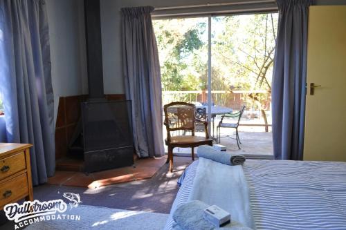 Un dormitorio con una cama y una chimenea y una mesa. en Sonata, en Dullstroom