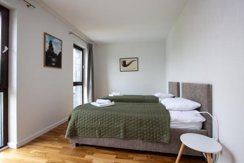 1 dormitorio con 1 cama con manta verde en Pine Home en Druskininkai