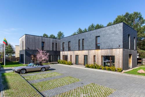 a house with a car parked in front of it at Pine Home in Druskininkai