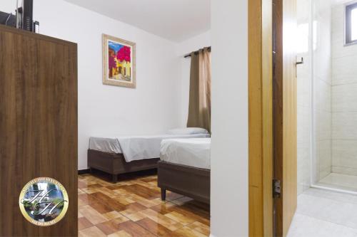 a bedroom with a bed and a shower and a door at Hotel Holiday Foz in Foz do Iguaçu