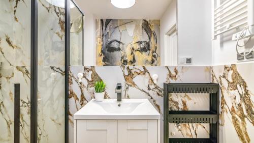 a bathroom with a sink and a shower at Baltic Garden Sztutowo Apartamenty PIAMOLA in Sztutowo