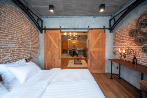 a bedroom with a bed and a brick wall at House of Machine Boutique Hotel in Bangkok