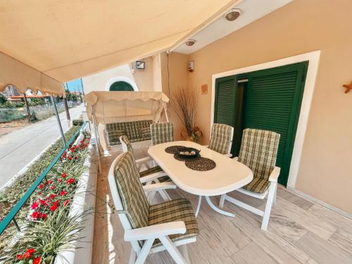 a patio with a table and chairs on a balcony at Almare House near Airport in Áyios Spirídhon