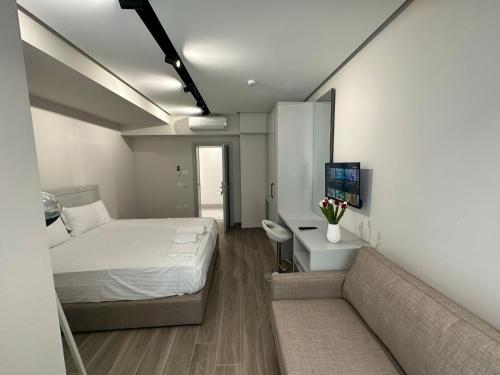 niewielka sypialnia z łóżkiem i kanapą w obiekcie Vila Kapllani Rooms w Durrës