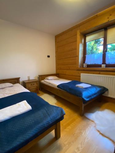 1 dormitorio con 2 camas y ventana en Apartament Zakopane Kościelisko en Kościelisko