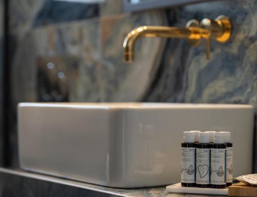 a bathroom sink with three bottles of toothpaste sitting next to it at Acropol Golden Suites in Neos Marmaras