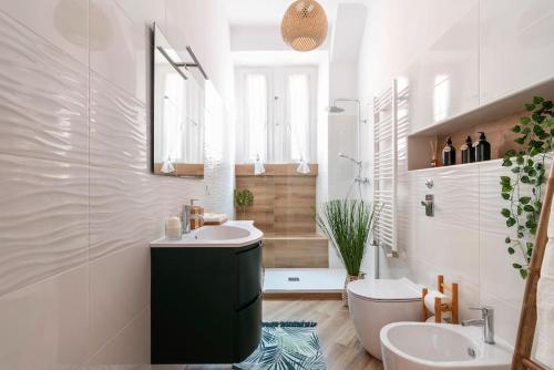 y baño con lavabo, aseo y espejo. en New Jungle & Charming Flat - zona De Angeli en Milán