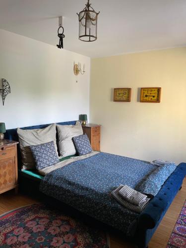 ein Schlafzimmer mit einem blauen Bett mit Kissen und einem Teppich in der Unterkunft Lindenhof ChezArtistes in Loose