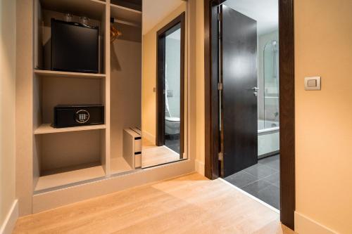 a hallway with a tv and a door to a bathroom at La Laguna Gran Hotel in La Laguna