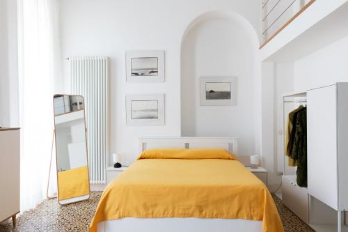 a white bedroom with a bed and a mirror at MARGHERITA 109 in Naples