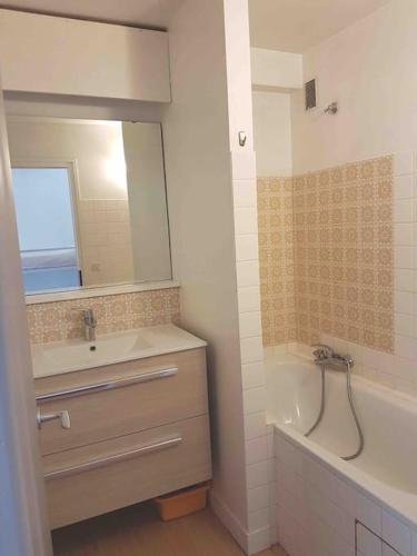 une salle de bain avec un lavabo, une baignoire et un miroir dans l'établissement SKI AUX PIEDS et PIEDS DANS L'EAU, aux Contamines-Montjoie