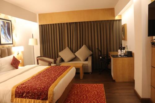 a hotel room with a bed and a couch at Days Inn by Wyndham Gangtok Tadong in Gangtok