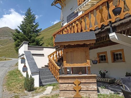 a building with a wooden staircase and a house at La Sapinière St Lary Soulan in Saint-Lary-Soulan