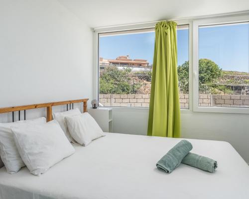 um quarto com uma grande cama branca e uma janela em Lo mejor de la montaña, Vista Bonita Atico em Jama