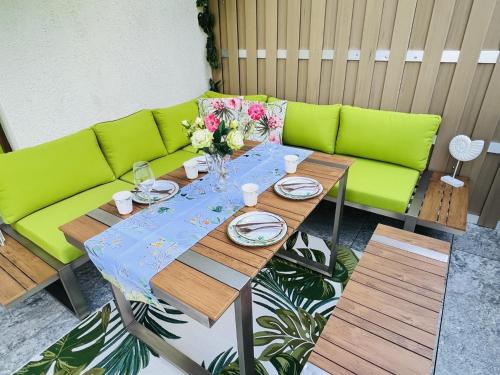 a table with a green couch and flowers on it at Ursula Maria in Ischgl