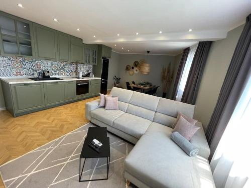 Una sala de estar con un sofá y una cocina. en Varna Top Center Luxury Apartment, en Varna