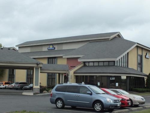 a car parked in a parking lot in front of a hotel at Days Inn by Wyndham Indianapolis Northeast in Indianapolis