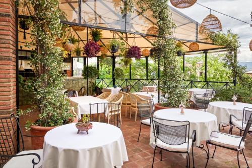 a restaurant with white tables and chairs and plants at GINGER Hotel in Tbilisi City