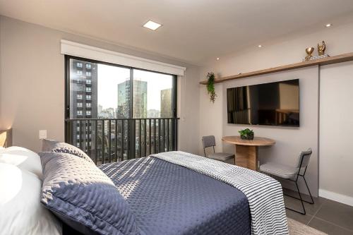 een slaapkamer met een bed en een balkon met een tafel bij Belo apto para casal com piscina GOS1007 in Porto Alegre