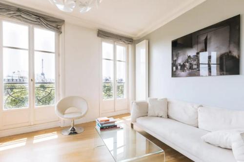 - un salon blanc avec un canapé blanc et des fenêtres dans l'établissement Central&Spacious 2BD Apart for 4 in Champs Elysées, à Paris