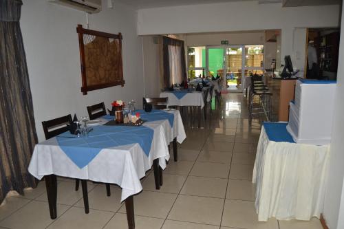 a restaurant with two tables with blue table cloth at THE ENCLAVE HOTEL in Francistown