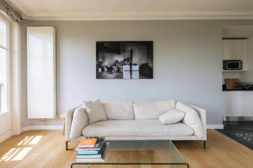 un salon avec un canapé blanc et une table en verre dans l'établissement Central&Spacious 2BD Apart for 4 in Champs Elysées, à Paris