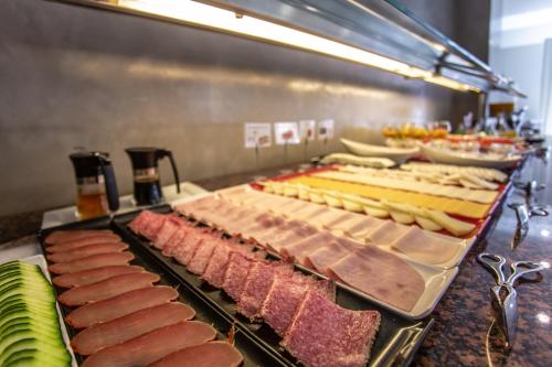 a buffet line with different types of meats and cheese at Hotel Monte Puertatierra in Cádiz
