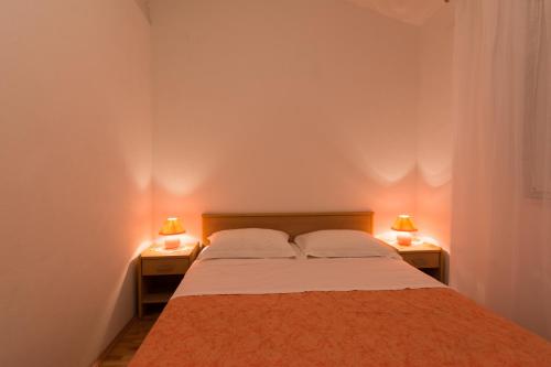 1 dormitorio con 1 cama y 2 lámparas en 2 mesas en Apartments Mirko, en Vinišće