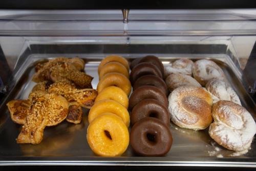 a tray full of different types of donuts at Hotel Monte Puertatierra in Cádiz