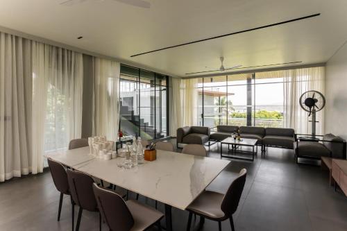 a living room with a large white table and chairs at Beyond by Sula in Nashik