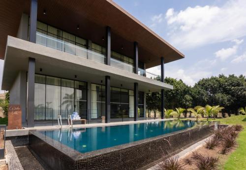 a house with a swimming pool in front of it at Beyond by Sula in Nashik