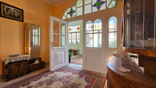 a hallway with a door and a room with windows at Kod Bake in Novi Bečej