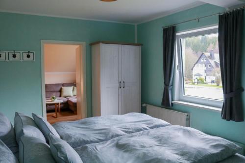 a bedroom with a large bed and a window at Haus Schmitten in Winterberg