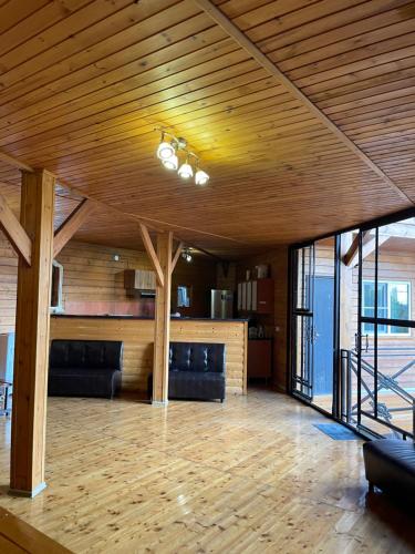 a large living room with a wooden ceiling and chairs at La Fontan in Sukhum